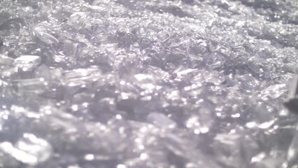 a tractor moves glass flasks in a disposal pile