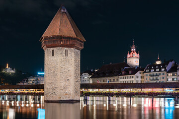 Chapel Bridge over river Reuss in Luzern, Switzerland at night with bright, colorful lights - obrazy, fototapety, plakaty