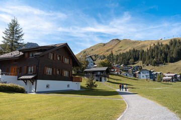 Fototapeta na wymiar Mountain houses in Stoos village in Switzerland. Swiss Alps ski resort in autumn or fall