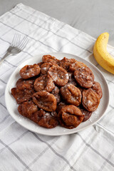 Homemade Banana Fritters with Powdered Sugar on a Plate, side view.