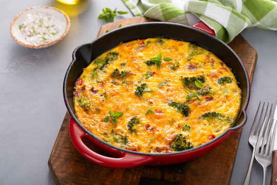 Healthy frittata or quiche with broccoli and red pepper whole in a cast iron pan