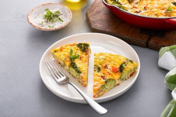 Healthy frittata or quiche with broccoli and red pepper, two slices on plate - obrazy, fototapety, plakaty