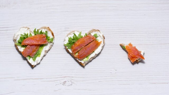 Making heart-shaped sandwiches with cream cheese, salmon and salad