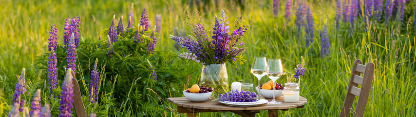 Elegant gorgeous wedding table decor or romantic dinner arrangement outdoors in blooming field....