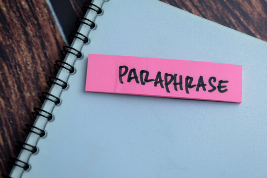 Concept of Paraphrase write on sticky notes isolated on Wooden Table.