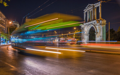Moving bus at night in the city of Athens. In the backround the Arch of Hadrian.