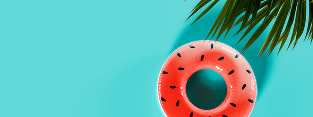 Watermelon inflatable rubber ring on turquoise blue background with copy space. Summer travel concept. 3D Rendering, 3D Illustration