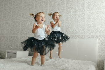 Two Little Girls Jumping on Bed in Snow