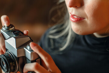 Woman Viewing Vintage Camera Indoors at Evening
