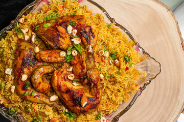 Chicken Kabsa, Homemade Arabian rice, Saudi food, Roasted chicken quarters and Nuts, on Wooden Background, Top View