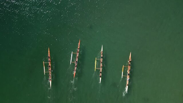 Overhead shot of athletic teams compete in boating on outrigger canoe, traditional Hawaiian boat in Oahu Island, Honolulu, Hawaii. High quality 4k footage