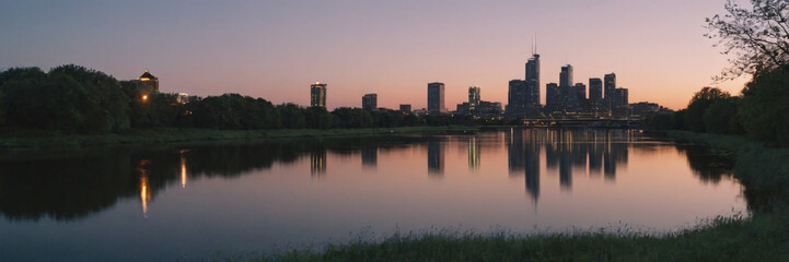 Fototapeta na wymiar Sunset and Greater City in the background of a beautiful river lake