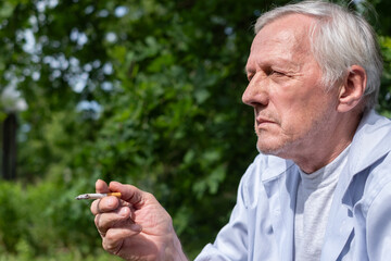 An elderly man takes a drag from a cigarette, enveloped in the serenity of his leafy garden, a...