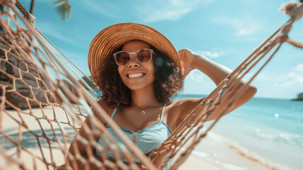 Beautiful ethnic woman relaxing at hammock between palm trees on an idyllic tropical beach,...