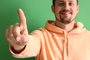 Handsome man using virtual screen on green background, closeup