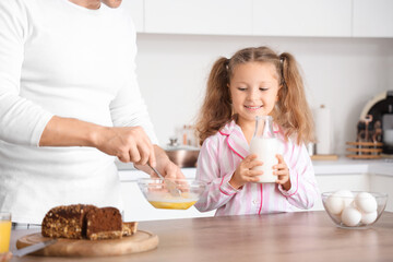 Obraz na płótnie Canvas Cute little girl with her dad making breakfast in kitchen
