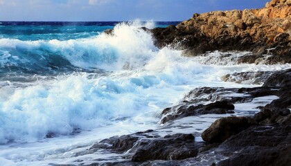 A dramatic storm churns the ocean, sending a massive wave crashing onto a rocky coastline, creating a chaotic scene of whitecapped foam.