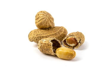 a macro closeup of several roasted peanuts in the shell and one peanut broken in half isolated on white