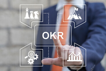 Man using virtual touchscreen presses acronym: OKR. Concept of Objectives and Key Results ( OKR )...