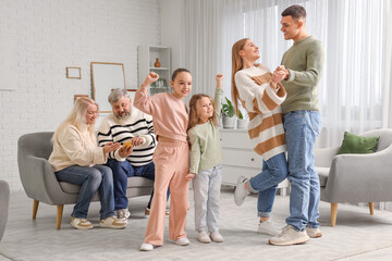 Little sisters with their parents dancing at home