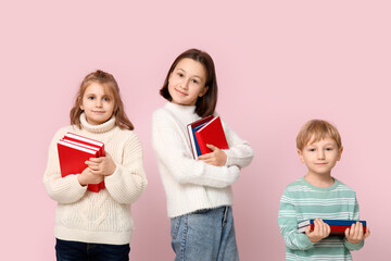 Little children with books on pink background