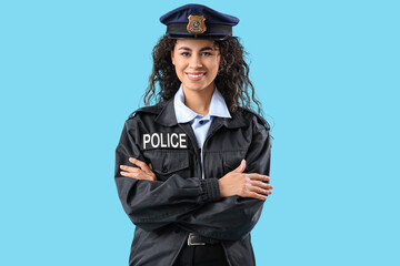 African-American female police officer with crossed arms on blue background