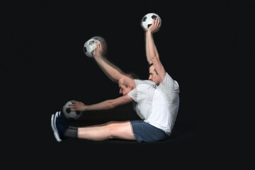 Sporty young man doing exercise with ball in motion on black background