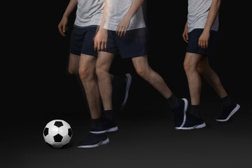 Fototapeta premium Man playing with soccer ball in motion on black background