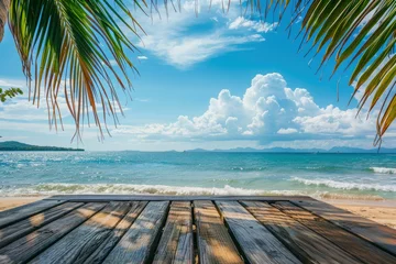 Deurstickers Summer tropical sea with waves, palm leaves and blue sky with clouds. Perfect vacation landscape with empty wooden table - generative ai © Nia™