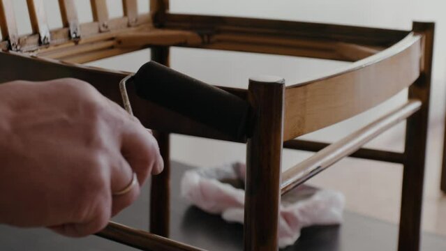 Restoration of a wooden chair. Covering with dark varnish. Close-up. Vintage things. High quality 4k footage