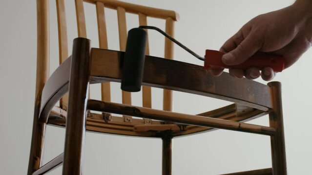 Restoration of a wooden chair. Covering with dark varnish. Close-up. Vintage things. High quality 4k footage