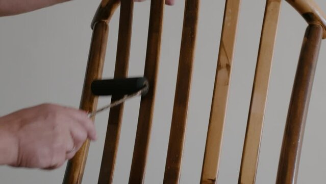 Restoration of a wooden chair. Covering with dark varnish. Close-up. Vintage things. High quality 4k footage