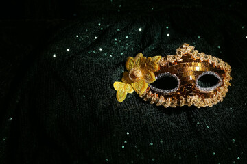 Golden carnival mask with flower on shiny green background
