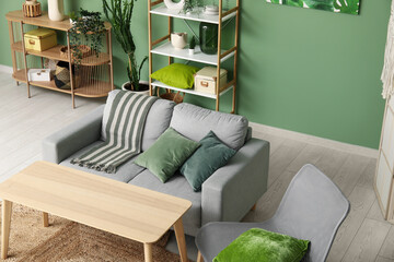 Interior of living room with comfortable sofa, olive pillows and wooden table