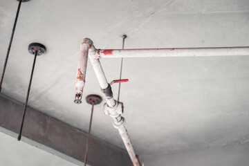 White and Red Fire Protective Water Pipeline and Sprinkler system on concrete Ceiling, Inspecting and improving systems to prevent fires in the first place. Copy space.