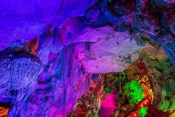 Beautiful illuminated multicolored stalactites from karst Reed Flute cave.