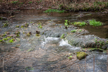 Selective blur on Streaming water, flowing through the rocks of a mountain stream brook, with a...