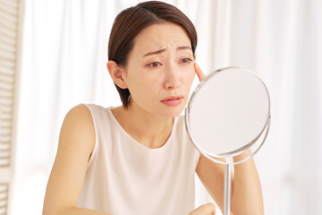 目尻のシワに悩む中年の女性