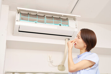 エアコンの臭いに困る女性