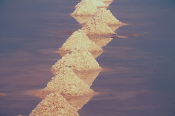 Close up view of the heaps of salt forming a pyramid and arranged in rows during the harvest season...