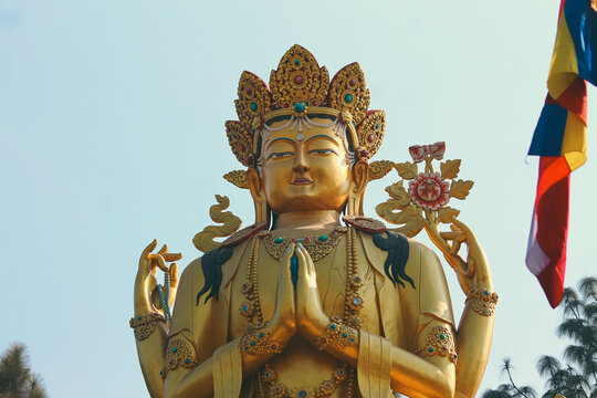 Ornate golden Avalokitesvara female Buddha statue against a clear blue sky background in Swayambhu Buddha Park Ring Road which is a popular tourist destination in Kathmandu, Nepal