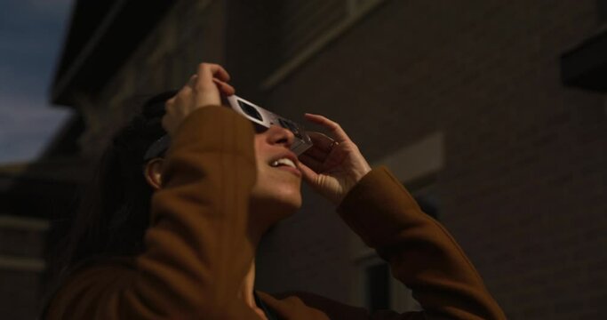 Ottawa Ontario Canada - April 8th 2024 - Woman wears iso 123 12-2 glasses and watches solar eclipse
