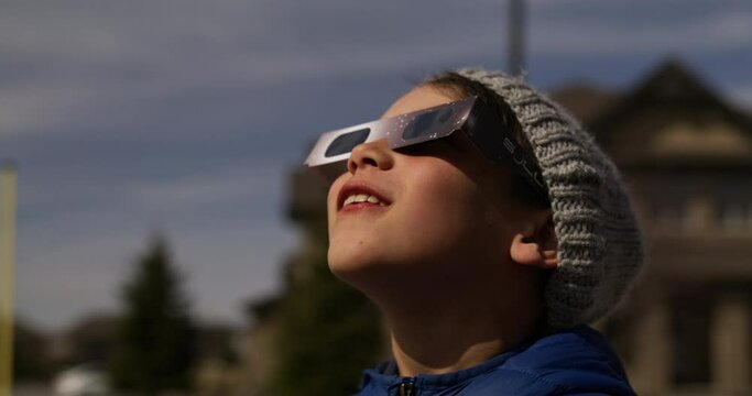 Ottawa Ontario Canada - April 8th 2024 - Young boy amazed watching Solar Eclipse 2024