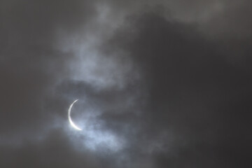 A sliver of the sun during 2024 Solar Eclipse; moon in the sky