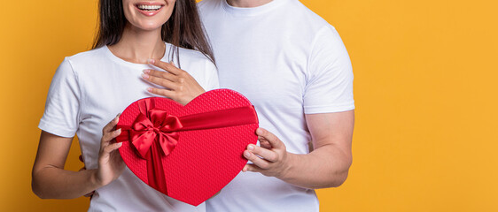 Sweetheart. Family couple with valentines present. Gift of heart. Man and woman isolated on yellow....