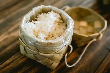 White sticky rice in a basket woven with palm leaves.