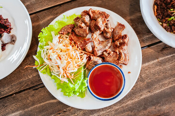 Pork intestines are battered and fried, placed in tomato sauce and shredded vegetables.