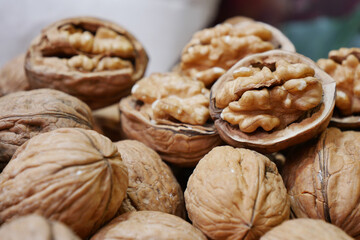 A scoop of walnuts, a superfood, rests on a stack of nuts seeds