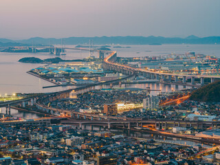 Beautiful top view of urban city with many buildings by the sea at night, Great Seto Bridge in Sakaide City in Kagawa Prefecture in Japan, Travel or outdoor, High resolution over 50MP