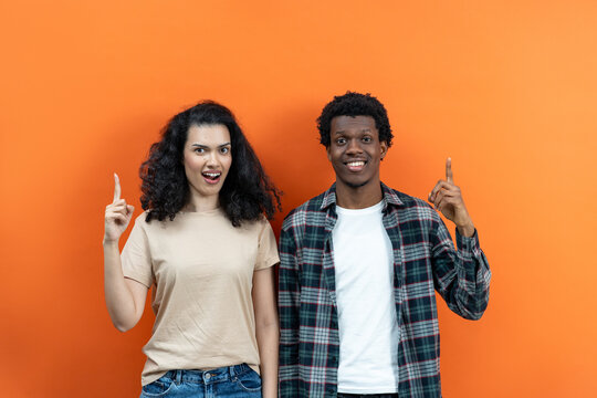 Happy Couple Pointing Up Ideas On Orange Background, Smiling Man Woman, Casual Clothes, Diverse Ethnicity, Eureka Moment, Creative Concept, Copy Space